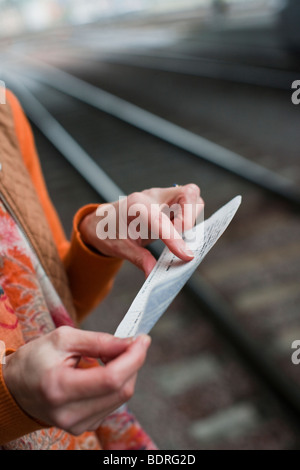 Una donna in una stazione ferroviaria Foto Stock