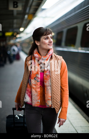 Una donna in una stazione ferroviaria Foto Stock