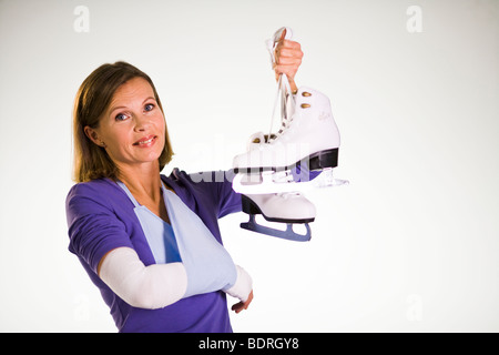 Una donna malata holding pattini. Foto Stock