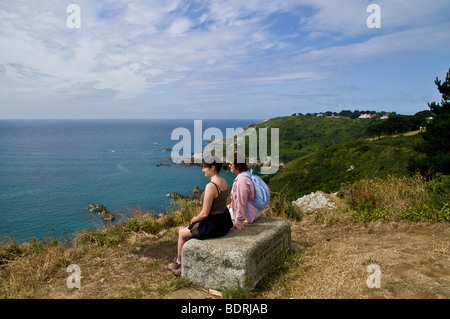 dh Moulin Huet Bay ST MARTIN GUERNSEY Donna e ragazza turisti costa meridionale madre persone vacanzieri seduti Foto Stock