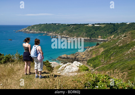 Dh Moulin Huet Bay St Martin Guernsey Donna e bambina cercando in vista della baia e della costa meridionale di persone i turisti di scena Foto Stock