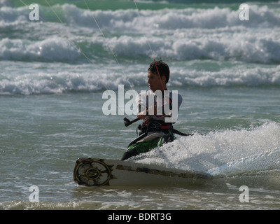 Kitesurfer accelerando attraverso le onde a Les Pieux, Normandia, Francia Foto Stock