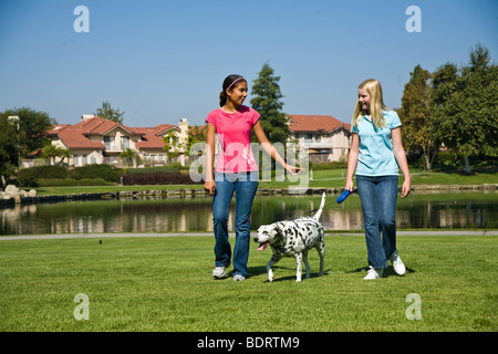 Appendere fuori razziale mixed mix razziali multi etnico Ispanico e Caucasico ragazze adolescenti a piedi Tween tween parlando.proprietario del cane davanti signor ©Myrleen Pearson Foto Stock