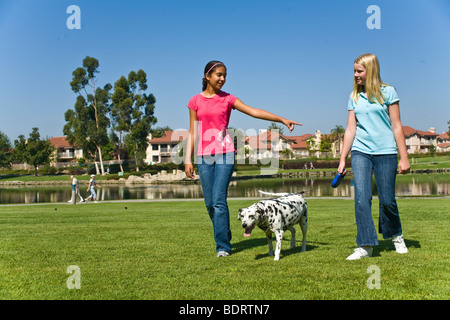 Tween tween appendere fuori razziale mixed mix razziali multi etnico Ispanico e Caucasico ragazze adolescenti a piedi cane dalmata e parlando davanti signor © Myrleen Pearson Foto Stock