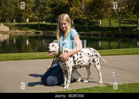 Lato viewCaucasian junior alta età 11-13 anni vecchia ragazza e cane dalmata proprietario degli STATI UNITI STATI UNITI STATI UNITI D'AMERICA . Signor © Myrleen Pearson Foto Stock