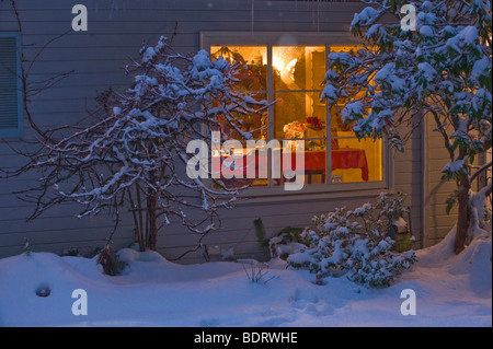 Accogliente casa calda sulla neve di notte Foto Stock