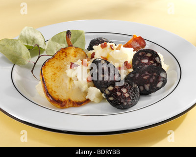 Salsicce di sangue con purè di patate e pancetta e pera su una piastra Foto Stock