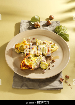 I CAVOLI DI BRUXELLES casseruola con le nocciole su un piatto di terracotta Foto Stock