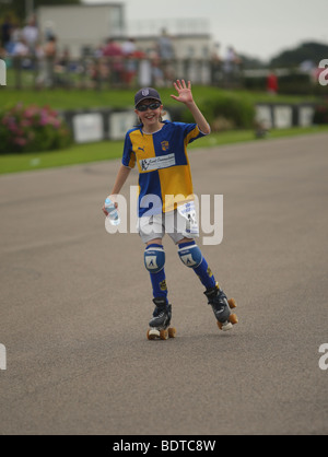 Un giovane pattinatore sorridente agitando in una maratona di beneficenza Foto Stock