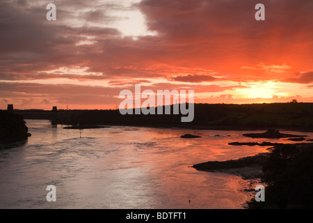 Menai Bridge Isola di Anglesey North Wales UK. Rosso tramonto sopra il Menai Strait sull'Isola di Anglesey costa da Menai Bridge Foto Stock