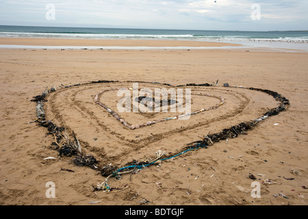 Schema a forma di cuore in alghe e pietre; Beach art e dune di sabbia paesaggio costiera a Fraserburgh Bay, Aberdeenshire, Scozia, Gran Bretagna. Foto Stock
