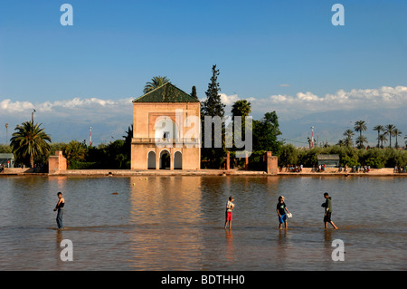 Ragazzi marocchini Wade attraverso il lago o la piscina di fronte la Menara Royal Pavilion di Giardini Menara marrakech marocco Foto Stock