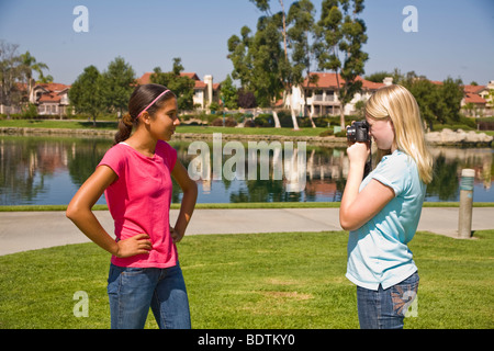 Junior caucasica ragazza alta prende la foto del suo amico ispanica.Signor © Myrleen Pearson Foto Stock