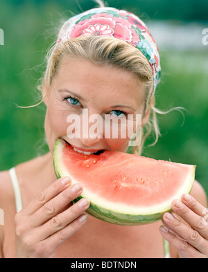 Una donna di mangiare un cocomero Foto Stock