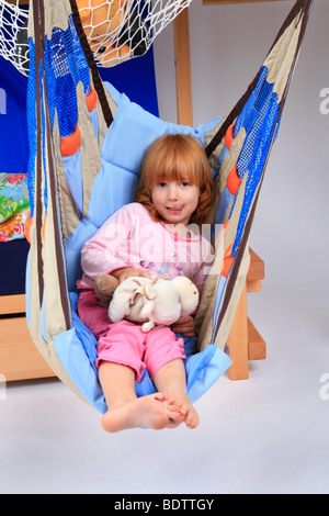 Bambina in una altalena di un Billi-Bolli loft bed Foto Stock