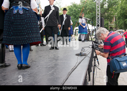 Ungherese di ballerini in abito tradizionale effettuando in corrispondenza di un festival di musica popolare in Budapest. Un fotografo è la registrazione della scena. Foto Stock