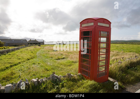 Telefono rosso casella nel paesaggio, Orkney Islands, SCOZIA Foto Stock