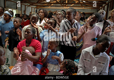 KENYA facce della congregazione alla messa cattolica in Mukuru Ruben, una delle baraccopoli di Nairobi. Canti e Balli. Foto Stock