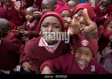 KENYA i bambini in uniformi di scuola giocando nel cortile della chiesa di Cristo Re scuola cattolica, Kibera, una delle baraccopoli di Nairobi. Foto Stock