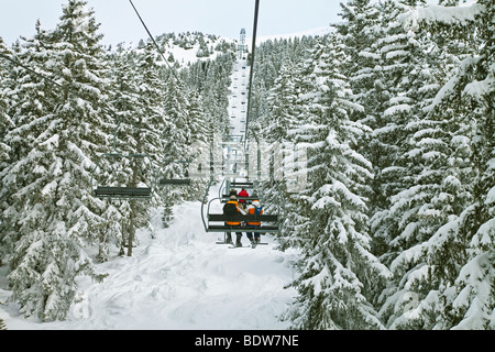 Gli sciatori in seggiovia, Méribel ski resort in tre valli, Les Trois Vallees, Savoie, sulle Alpi francesi, Francia Foto Stock