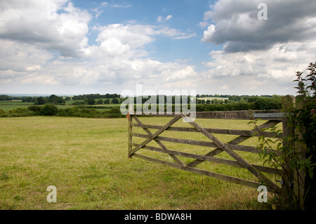 Un open farm Gate leading per un campo Foto Stock