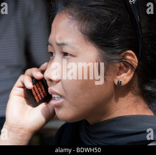 Kathmandu, Nepal. Giovani nepalesi donna tramite telefono cellulare. Nota diamond naso-pin. Foto Stock