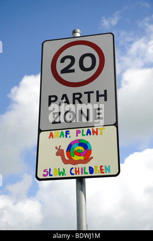 20 miglia per ora la zona bilingue segno, con dipinti a mano bassa "bambini" immagine di lumaca in gallese e inglese, Wales UK Foto Stock