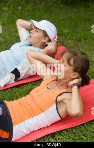 Due donne fanno sit ups, training addominale Foto Stock