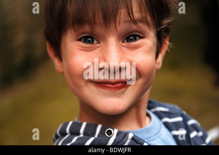 Little Boy rendendo volti Foto Stock