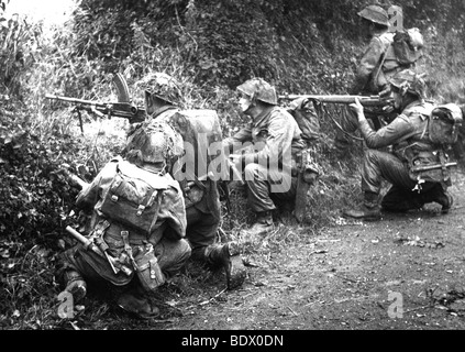 Il D-Day 1944 - Classic British unità di fanteria con Bren gunner sparare attraverso un gap in 'bocage' hedgerows supportato da fucilieri Foto Stock