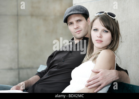 Coppia giovane seduti insieme su una panchina nel parco Foto Stock