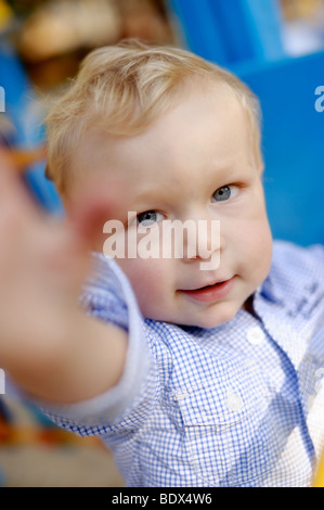 Little Boy a cercare di afferrare la fotocamera Foto Stock