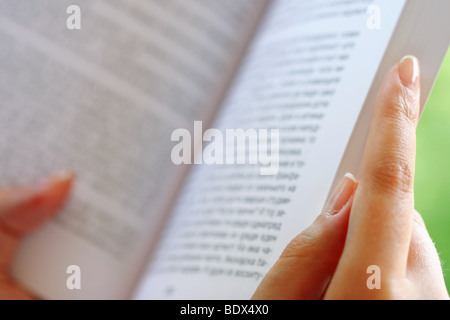 Mano femminile in possesso di un libro, all'aperto Foto Stock