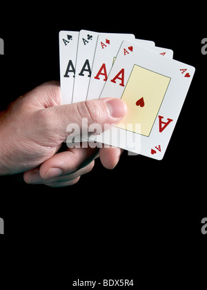 Una mano d'uomo azienda quattro assi isolati su sfondo nero. Foto Stock