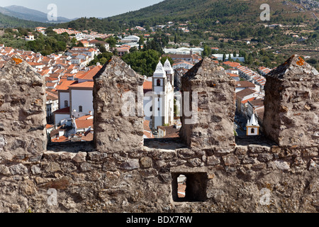 Santa Maria da Devesa Chiesa visibile attraverso il castello torre di avvistamento merlata a Castelo de Vide, Alto Alentejo, Portogallo. Foto Stock