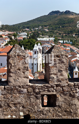 Santa Maria da Devesa Chiesa visibile attraverso il castello torre di avvistamento merlata a Castelo de Vide, Alto Alentejo, Portogallo. Foto Stock