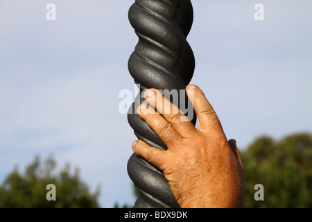 Una mano d'uomo appoggiato su di una spirale lampada post Foto Stock