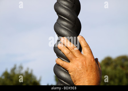 Una mano d'uomo appoggiato su di una spirale lampada post Foto Stock