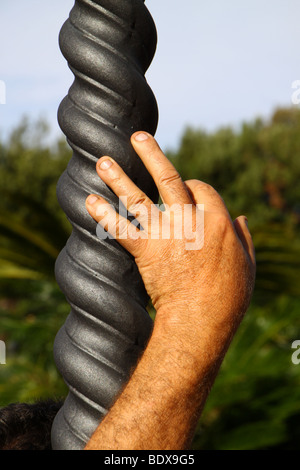 Una mano d'uomo appoggiato su di una spirale lampada post Foto Stock