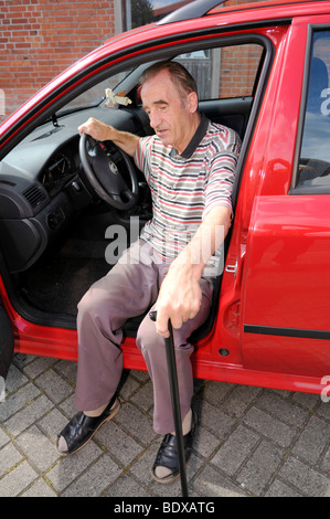 Uomo senior di entrare in una macchina Foto Stock