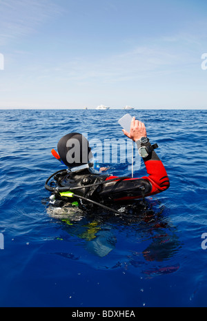 Il drifting subacqueo in mare è il tentativo di ottenere l'attenzione di persone su navi di immersioni all'orizzonte da lampeggiante con uno specchio, Egitto, R Foto Stock
