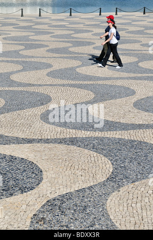 I turisti presso il fiume Tago, camminando sul marciapiede in ciottoli con andamento ondulato, Belem, Lisbona, Portogallo, Europa Foto Stock