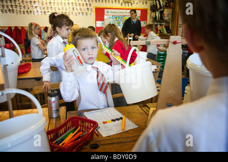 I bambini in un Regno Unito la scuola primaria facendo un esperimento scientifico Foto Stock