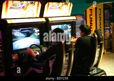 I ragazzi adolescenti la riproduzione di guida arcade game Foto Stock