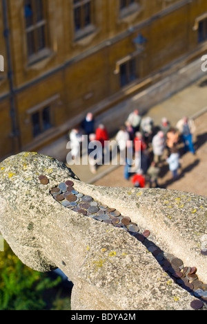 Le monete gettate dai turisti in un gargoyle alta sulla torre dell'università chiesa di Santa Maria Vergine, Oxford, Inghilterra Foto Stock