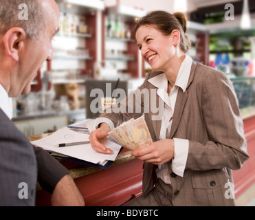 Imprenditrice di pagare l'uomo in bar Foto Stock