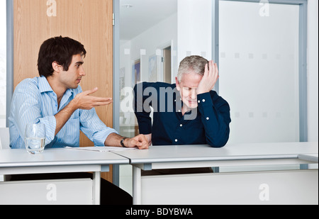L'uomo consolante collega di lavoro Foto Stock