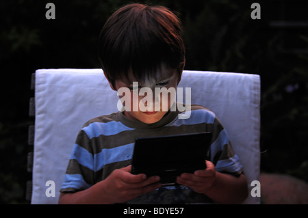 Little Boy giocando con il suo gioco DS, a doppio schermo di gioco Foto Stock