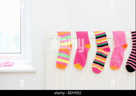 Calze colorate asciugatura sul radiatore Foto Stock