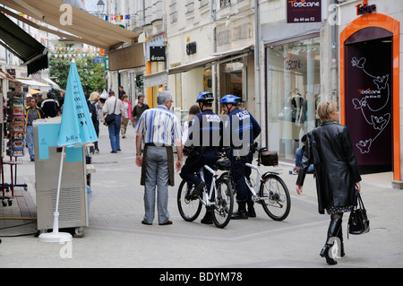 Poliziotti municipali in bici parlando a un negoziante, Rue du Commerce, Blois, Loir et Cher, Centre, Francia (solo editoriale). Foto Stock
